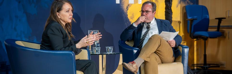 Marcie Frost and Peter Spiegel seated on a stage