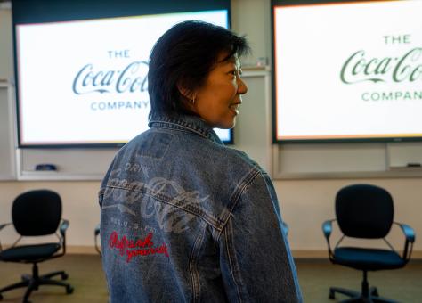 Woman wearing a denim jacket with a Coca Cola logo on the back