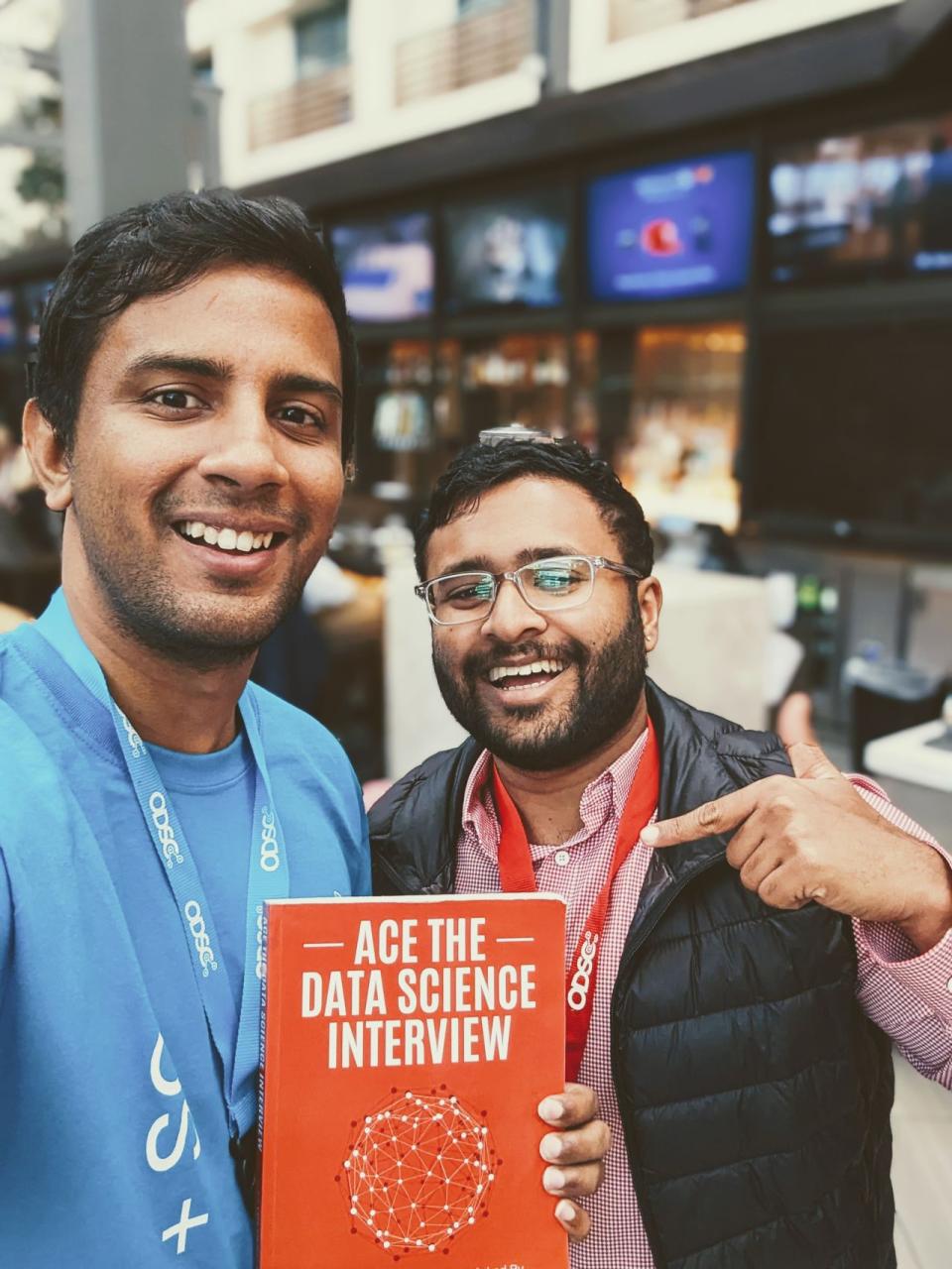 Laksh Suryanarayanan holding book with Author Nick Singh at a conference