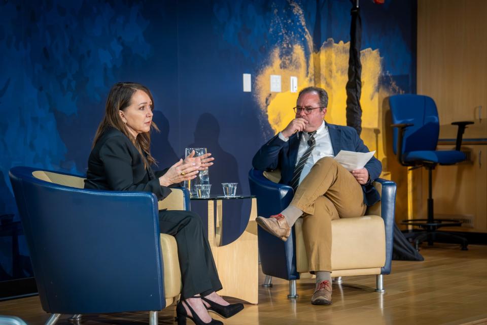 Marcie Frost and Peter Spiegel seated on a stage