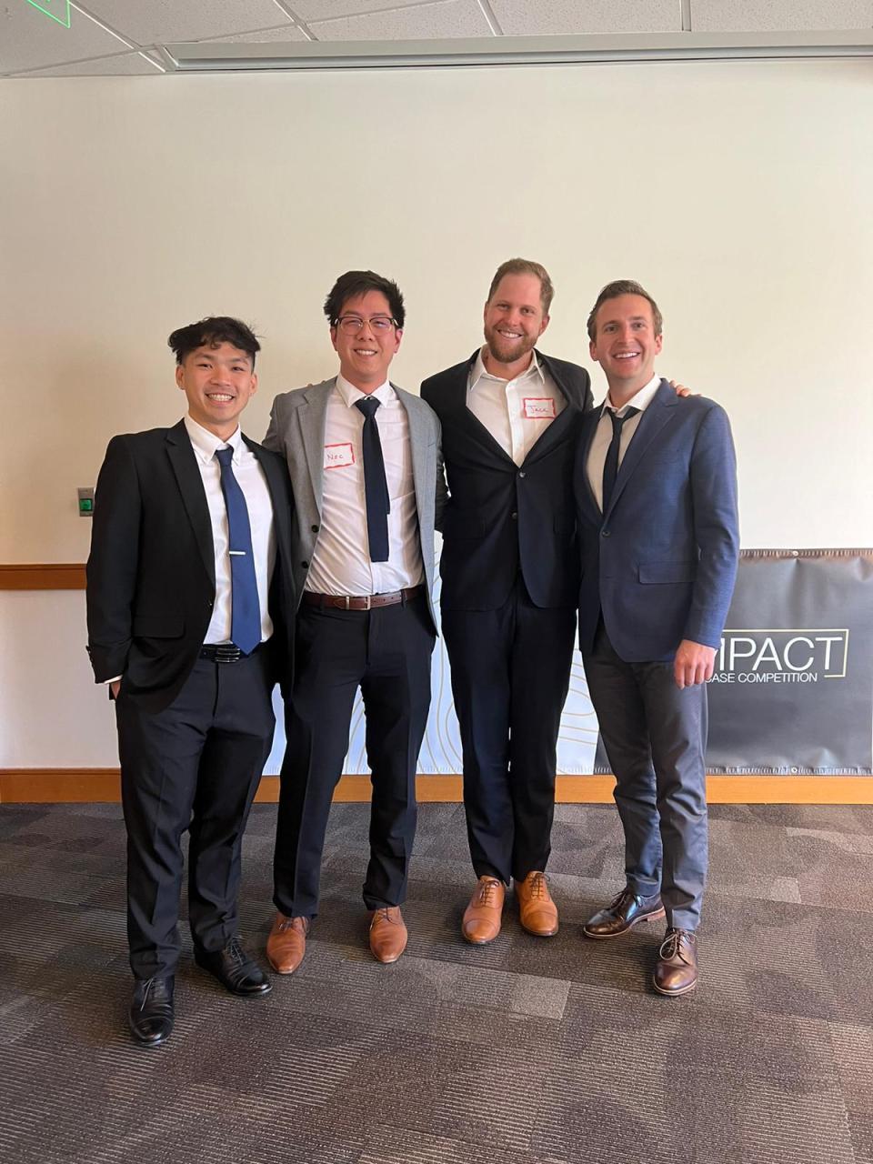 Minh Thieu Nguyen, Nic Seto, Jack Schaufler, Andrew Robert Collins dressed in professional attire at the Net Impact Case Competition