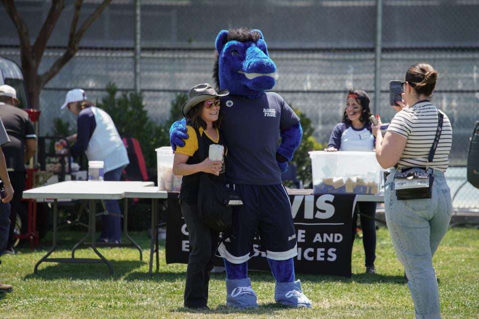 Gunrock the mascot and an UC Davis employee standing on Russell Field 